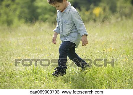 Little boy walking in field View Large Photo Image Stock Image - Little boy walking in field. Fotosearch