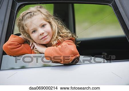 Picture - Little girl leaning out car window, portrait. Fotosearch