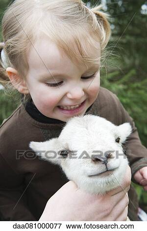 Stock Photo - Little girl petting lamb. Fotosearch