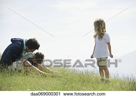 Little girl watching as her father consoles her brother View Large Photo Image Stock Image - Little girl watching as her father consoles her brother. Fotosearch
