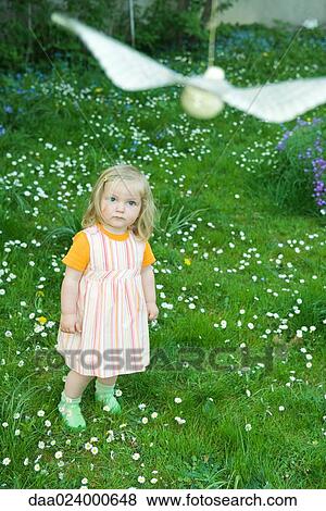 Little girl watching fake bird hanging from string View Large Photo Image Stock Photo - Little girl watching fake bird hanging from string. Fotosearch