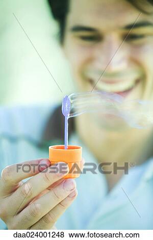 Stock Photo - Man blowing bubbles. Fotosearch