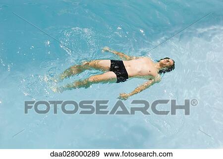 Man floating on back in swimming pool, high angle view View Large Photo Image Stock Photo - Man floating on back in swimming pool, high angle view. Fotosearch