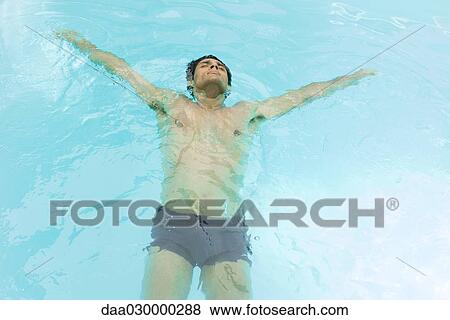 Man floating on back in swimming pool View Large Photo Image Stock Photo - Man floating on back in swimming pool. Fotosearch