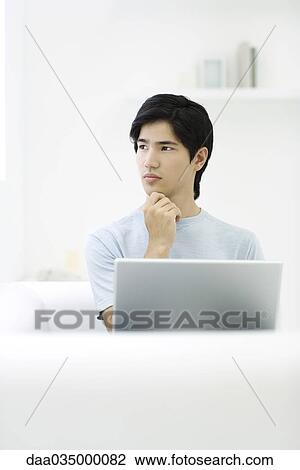 Man holding chin and looking away View Large Photo Image Stock Image - Man holding chin and looking away. Fotosearch