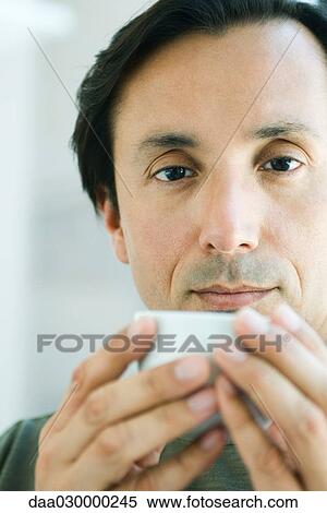 Man holding cup, looking at camera, portrait View Large Photo Image Stock Photography - Man holding cup, looking at camera, portrait. Fotosearch