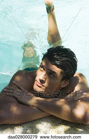Man holding on to edge of swimming pool with arms folded, looking up, high angle view View Large Photo Image Stock Photo - Man holding on to edge of swimming pool with arms folded, looking up, high angle view. Fotosearch