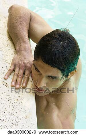 Stock Photo - Man holding on to side of swimming pool, close-up, high angle view. Fotosearch