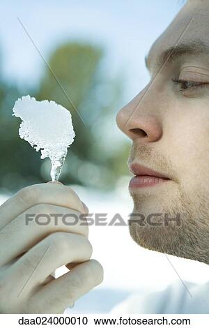 Man holding piece of ice close to face, close-up View Large Photo Image Stock Image - Man holding piece of ice close to face, close-up. Fotosearch