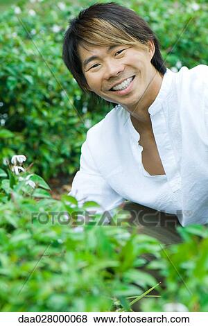 Man in garden, smiling at camera View Large Photo Image Stock Photo - Man in garden, smiling at camera. Fotosearch