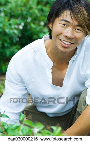 Man in garden, smiling at camera, portrait View Large Photo Image Stock Photograph - Man in garden, smiling at camera, portrait. Fotosearch