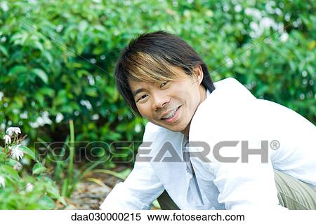 Stock Photography - Man in garden, smiling at camera. Fotosearch