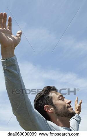 Man in outdoors with arms outstretched and eyes closed View Large Photo Image Stock Photo - Man in outdoors with arms outstretched and eyes closed. Fotosearch