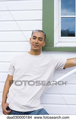Picture - Man leaning against railing, looking away. Fotosearch