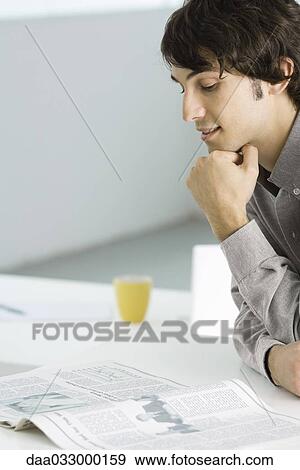 Man leaning against table on elbows, reading newspaper View Large Photo Image Stock Photo - Man leaning against table on elbows, reading newspaper. Fotosearch