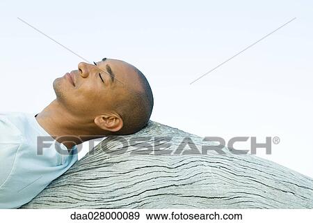 Man leaning back against wood surface, eyes closed View Large Photo Image Stock Photo - Man leaning back against wood surface, eyes closed. Fotosearch