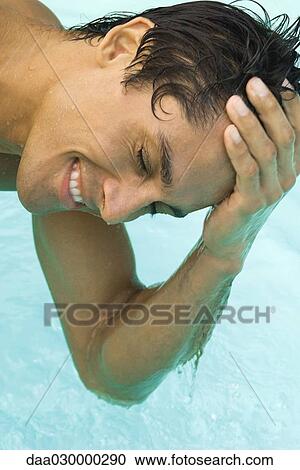 Man leaning over swimming pool with hand on head, eyes closed, close-up View Large Photo Image Stock Image - Man leaning over swimming pool with hand on head, eyes closed, close-up. Fotosearch
