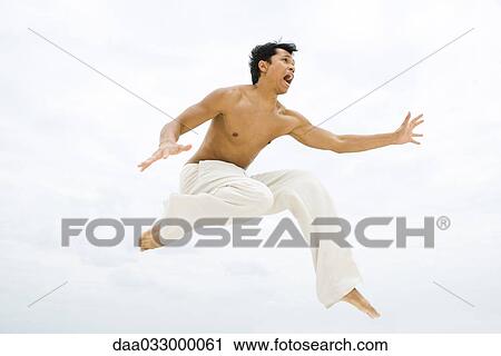 Man leaping in the air, side view View Large Photo Image Stock Image - Man leaping in the air, side view. Fotosearch