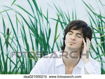 Man listening to headphones, eyes closed View Large Photo Image Stock Photography - Man listening to headphones, eyes closed. Fotosearch