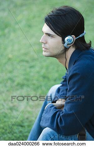 Stock Photograph - Man listening to headphones outdoors. Fotosearch