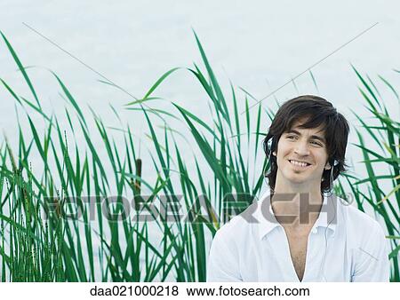 Man listening to headphones, smiling View Large Photo Image Stock Photo - Man listening to headphones, smiling. Fotosearch