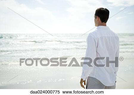 Man looking at ocean, rear view View Large Photo Image Stock Photography - Man looking at ocean, rear view. Fotosearch