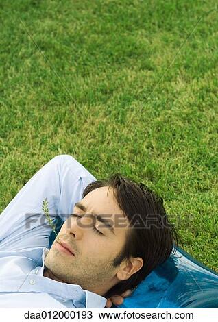 Man lying in grass with sprig of vegetation in mouth View Large Photo Image Stock Image - Man lying in grass with sprig of vegetation in mouth. Fotosearch