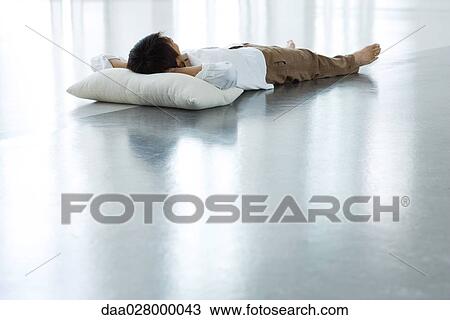 Man lying on floor with head on pillow, full length View Large Photo Image Stock Image - Man lying on floor with head on pillow, full length. Fotosearch