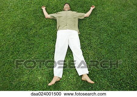Man lying on grass, full length View Large Photo Image Stock Image - Man lying on grass, full length. Fotosearch
