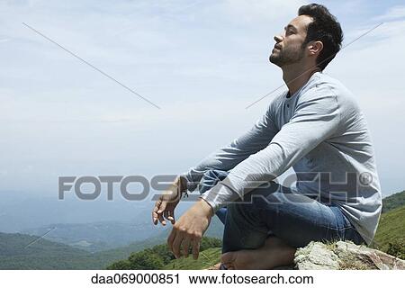 Man meditating on hilltop View Large Photo Image Stock Image - Man meditating on hilltop. Fotosearch