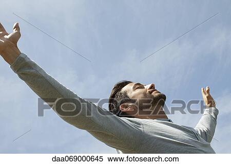 Man outdoors on sunny day, arms raised in air and eyes closed View Large Photo Image Stock Photography - Man outdoors on sunny day, arms raised in air and eyes closed. Fotosearch
