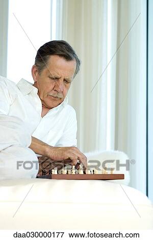 Stock Photo - Man playing chess. Fotosearch