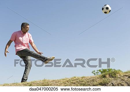 Man playing with soccer ball outdoors, smiling View Large Photo Image Stock Photography - Man playing with soccer ball outdoors, smiling. Fotosearch