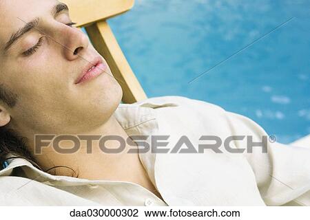 Man reclining in lounge chair beside pool, eyes closed, close-up View Large Photo Image Stock Image - Man reclining in lounge chair beside pool, eyes closed, close-up. Fotosearch