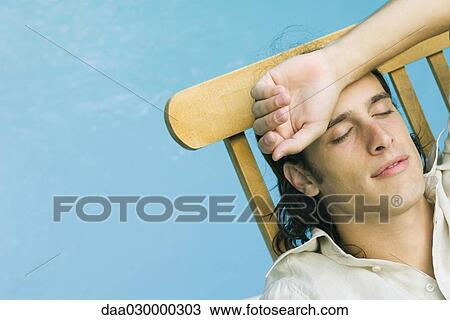 Man reclining in lounge chair beside pool, eyes closed, arm on head View Large Photo Image Stock Image - Man reclining in lounge chair beside pool, eyes closed, arm on head. Fotosearch