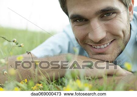 Man relaxing on meadow, cropped View Large Photo Image Stock Image - Man relaxing on meadow, cropped. Fotosearch