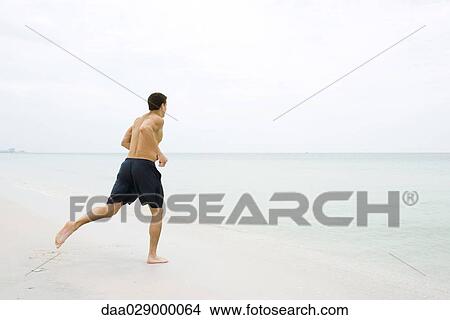 Man running at the beach, side view View Large Photo Image Picture - Man running at the beach, side view. Fotosearch