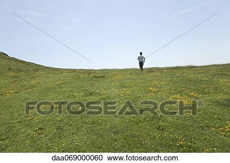 Man running through meadow View Large Photo Image Stock Image - Man running through meadow. Fotosearch