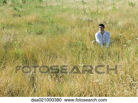 Man sitting in field, eyes closed View Large Photo Image Stock Image - Man sitting in field, eyes closed. Fotosearch