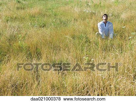 Man sitting in field, head back and eyes closed View Large Photo Image Stock Photo - Man sitting in field, head back and eyes closed. Fotosearch