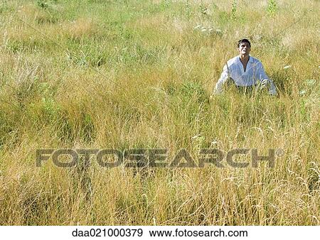 Man sitting in field, head back and eyes closed View Large Photo Image Stock Photo - Man sitting in field, head back and eyes closed. Fotosearch