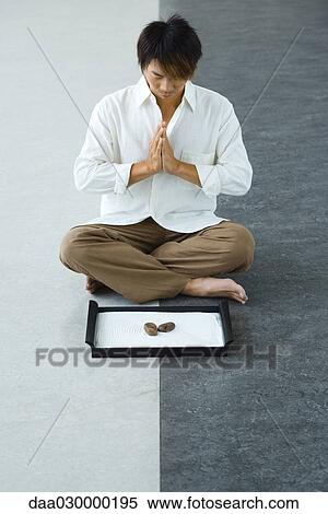 Man sitting in front of rock garden in lotus position, hands clasped View Large Photo Image Stock Photography - Man sitting in front of rock garden in lotus position, hands clasped. Fotosearch