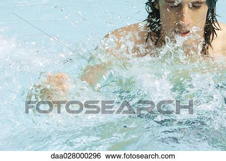 Man splashing in swimming pool, close-up View Large Photo Image Stock Photograph - Man splashing in swimming pool, close-up. Fotosearch
