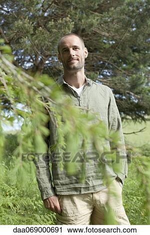 Stock Image - Man standing outdoors, portrait. Fotosearch
