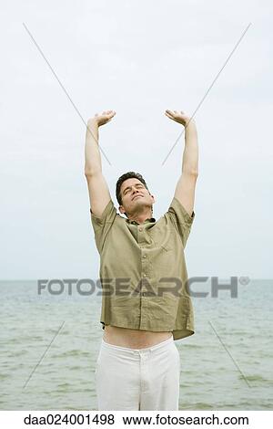 Man stretching in front of ocean, front view View Large Photo Image Stock Photo - Man stretching in front of ocean, front view. Fotosearch