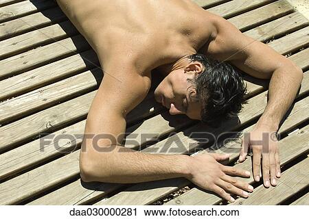 Man sunbathing on deck, eyes closed View Large Photo Image Stock Image - Man sunbathing on deck, eyes closed. Fotosearch