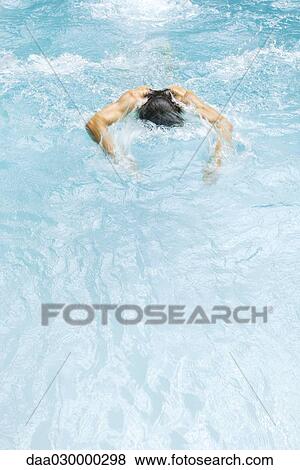 Stock Photo - Man swimming in pool, high angle view. Fotosearch