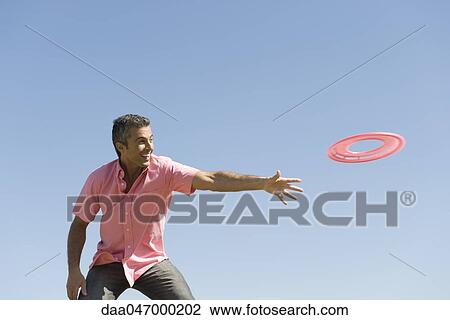 Man throwing flying disc View Large Photo Image Stock Image - Man throwing flying disc. Fotosearch