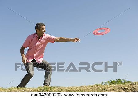Stock Image - Man throwing flying disc. Fotosearch