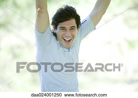 Man with arms raised, smiling at camera View Large Photo Image Stock Image - Man with arms raised, smiling at camera. Fotosearch